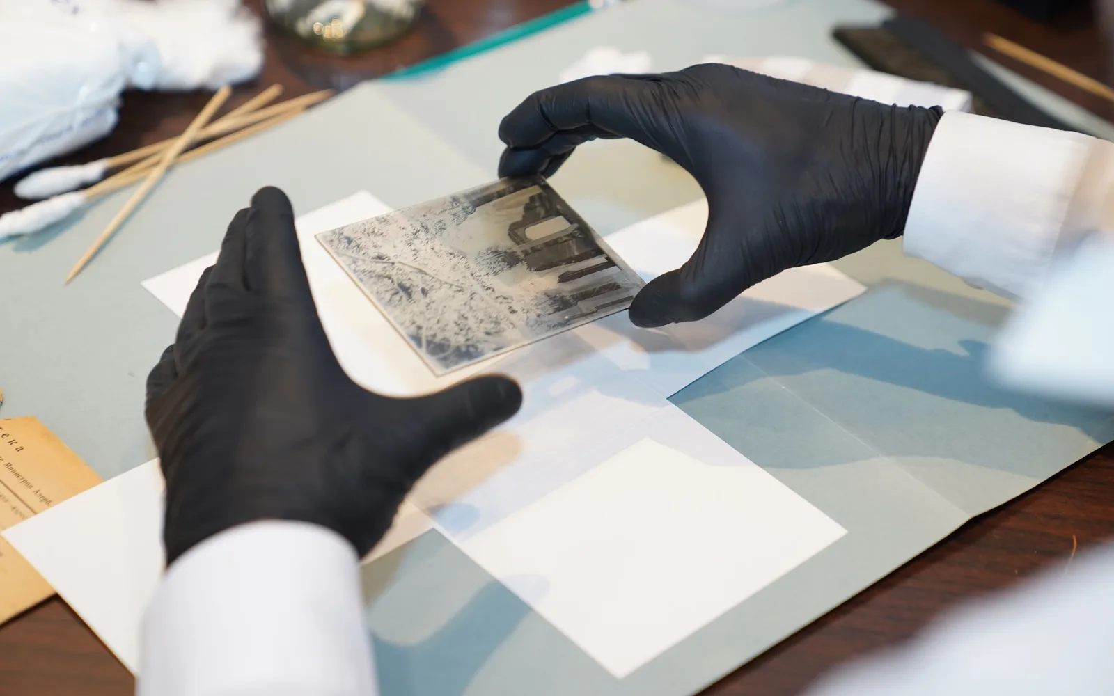 Conservator wearing gloves while restoring a historic photograph